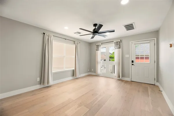 a view of a livingroom with wooden floor and a ceiling fan