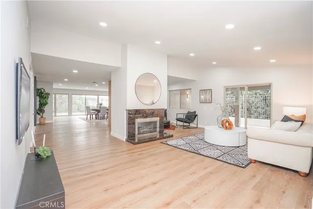 a living room with furniture a large window and a fireplace