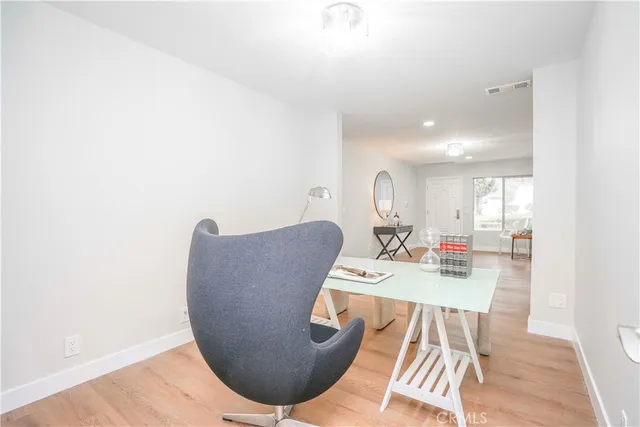 a living room with furniture a wooden floor and a kitchen view