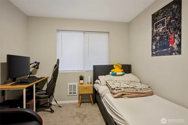 a bedroom with a bed and a computer on a desk