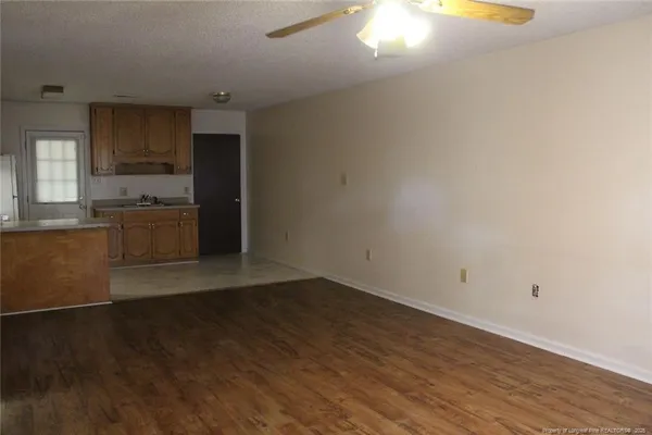 an empty room with kitchen appliances and wooden floor