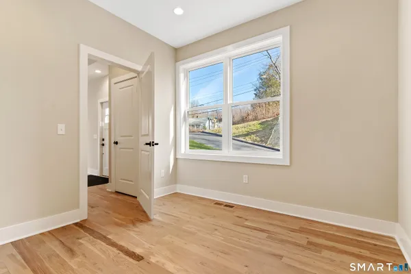 an empty room with wooden floor and a window