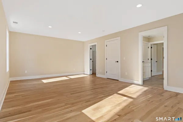 a view of an empty room with wooden floor