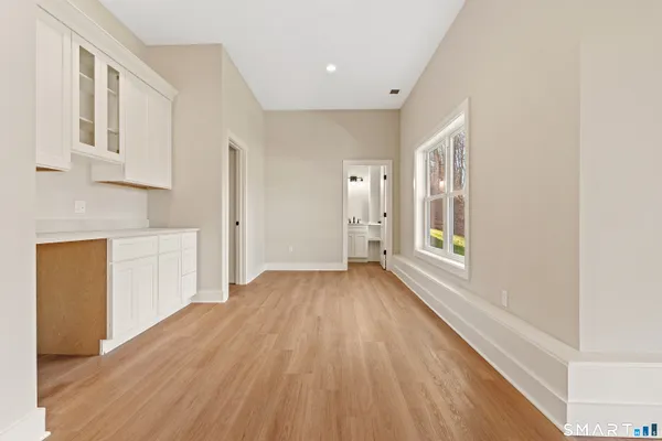 a view of a kitchen with wooden floor and electronic appliances