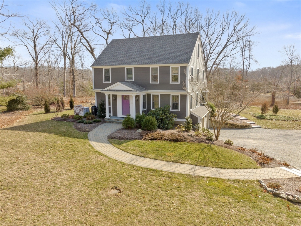 a view of a white house with a large pool and lawn chairs under wooden roof