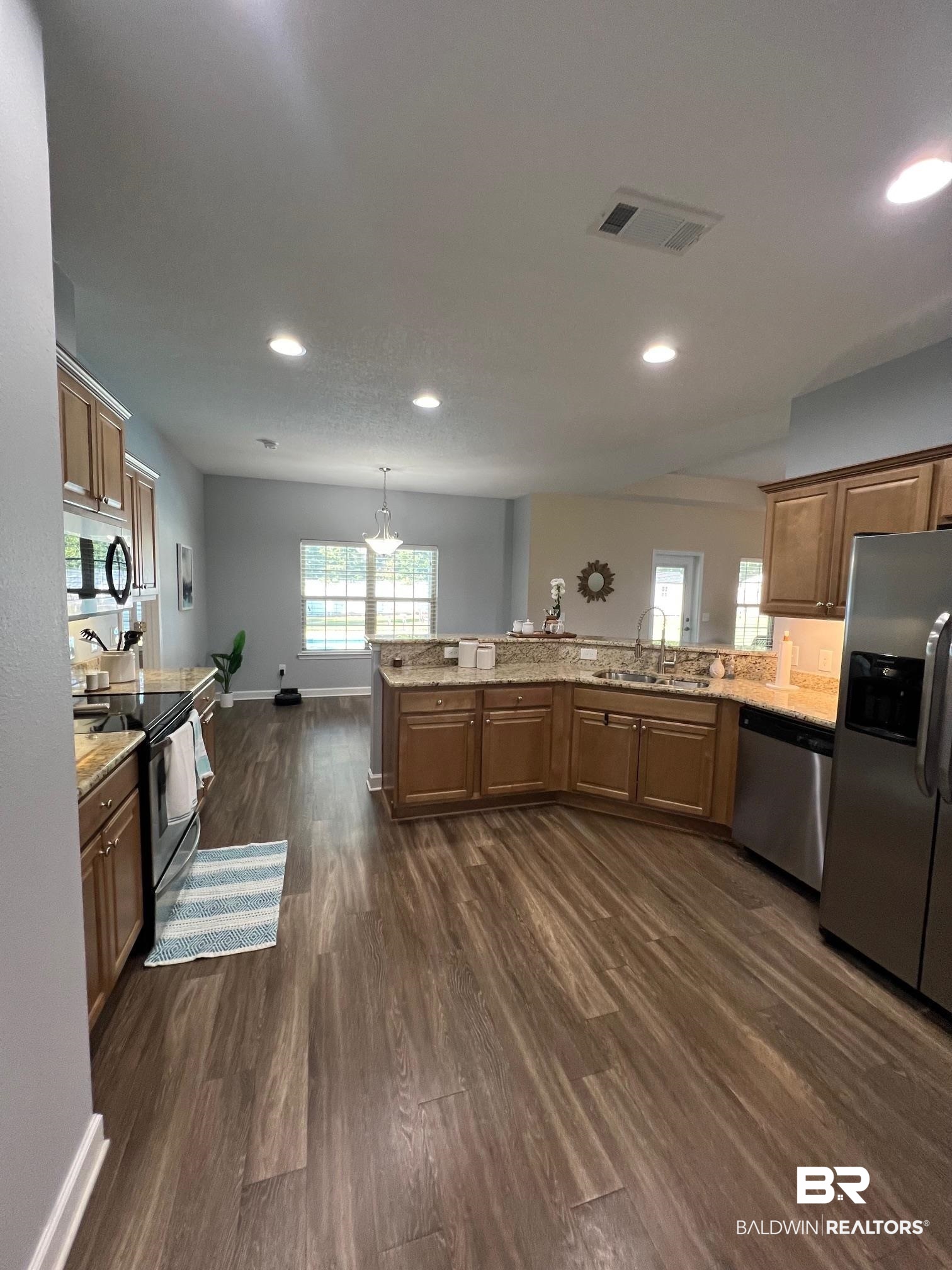 10257 Lyttleton Loop Lillian, AL 36549 - Photo 10 of 31 Kitchen featuring hanging light fixtures, stainless steel appliances, dark wood-type flooring, brown cabinets, and recessed lighting