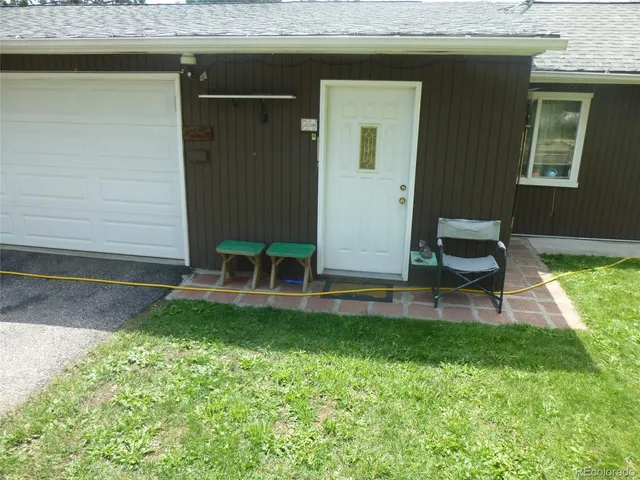 a backyard of a house with barbeque oven and plants