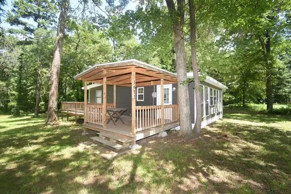 a porch with a table and chairs under an umbrella