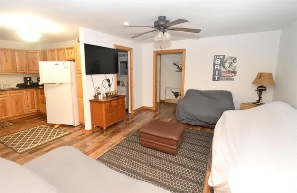 a living room with a bed furniture and a flat screen tv