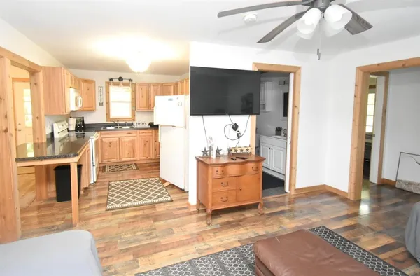 a living room with stainless steel appliances kitchen island granite countertop a stove and a view of living room
