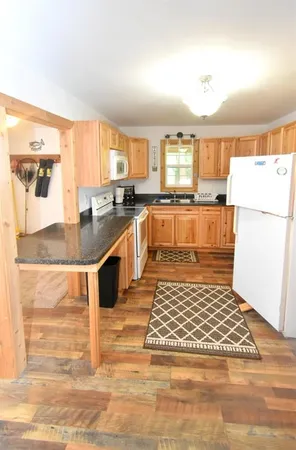 a large kitchen with kitchen island granite countertop a stove a sink and a refrigerator