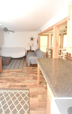 a living room with couches painting on the wall and a large window