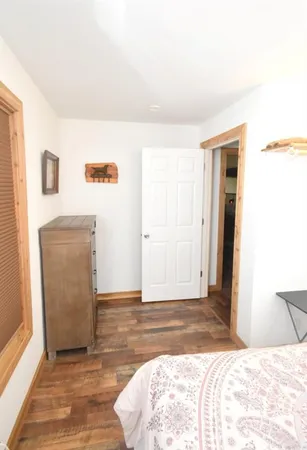 a view of a bedroom with wooden floor and cabinet