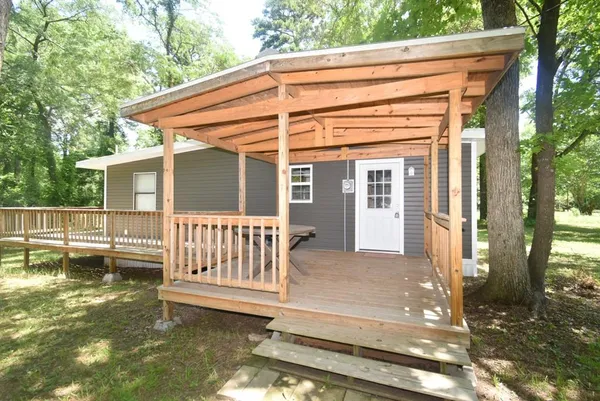 a view of a house with backyard and deck