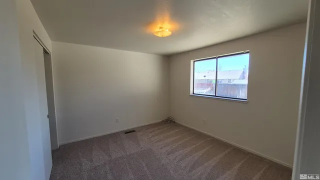 an empty room with a window and a lamp