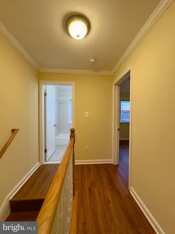 a view of a hallway with wooden floor and staircase