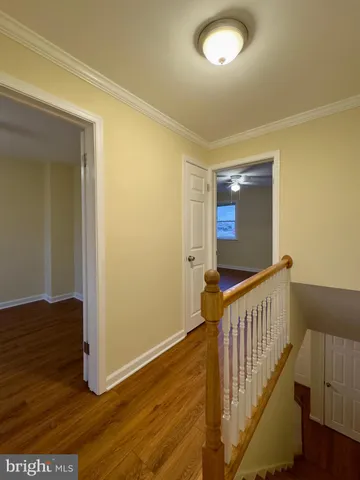 a view of a hallway with wooden floor and staircase