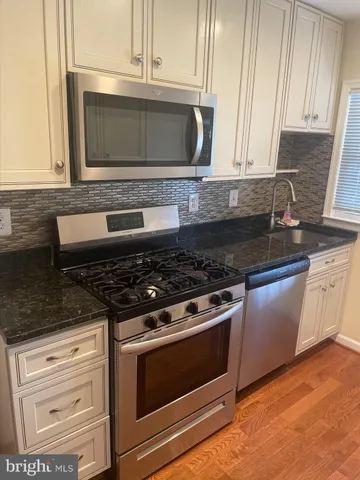 a stove top oven sitting inside of a kitchen
