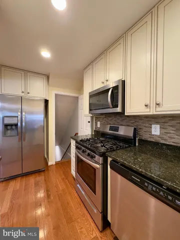 a kitchen with stainless steel appliances granite countertop a stove a refrigerator and a microwave