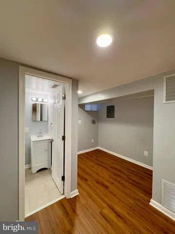 a view of a room with wooden floor and a sink