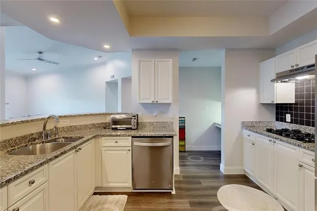 a kitchen with a granite countertop sink and cabinets