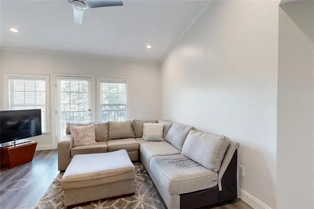 a living room with furniture a flat screen tv and a window