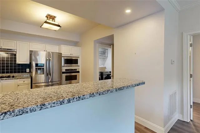 a kitchen with stainless steel appliances granite countertop a sink and a refrigerator