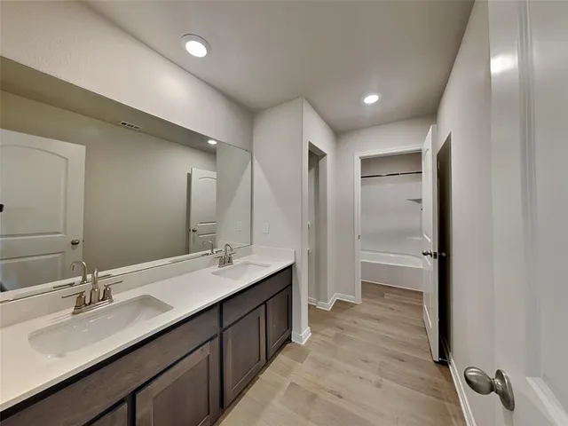 a bathroom with a double vanity sink a mirror and a shower