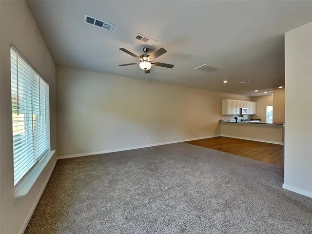 en empty room with windows and ceiling fan