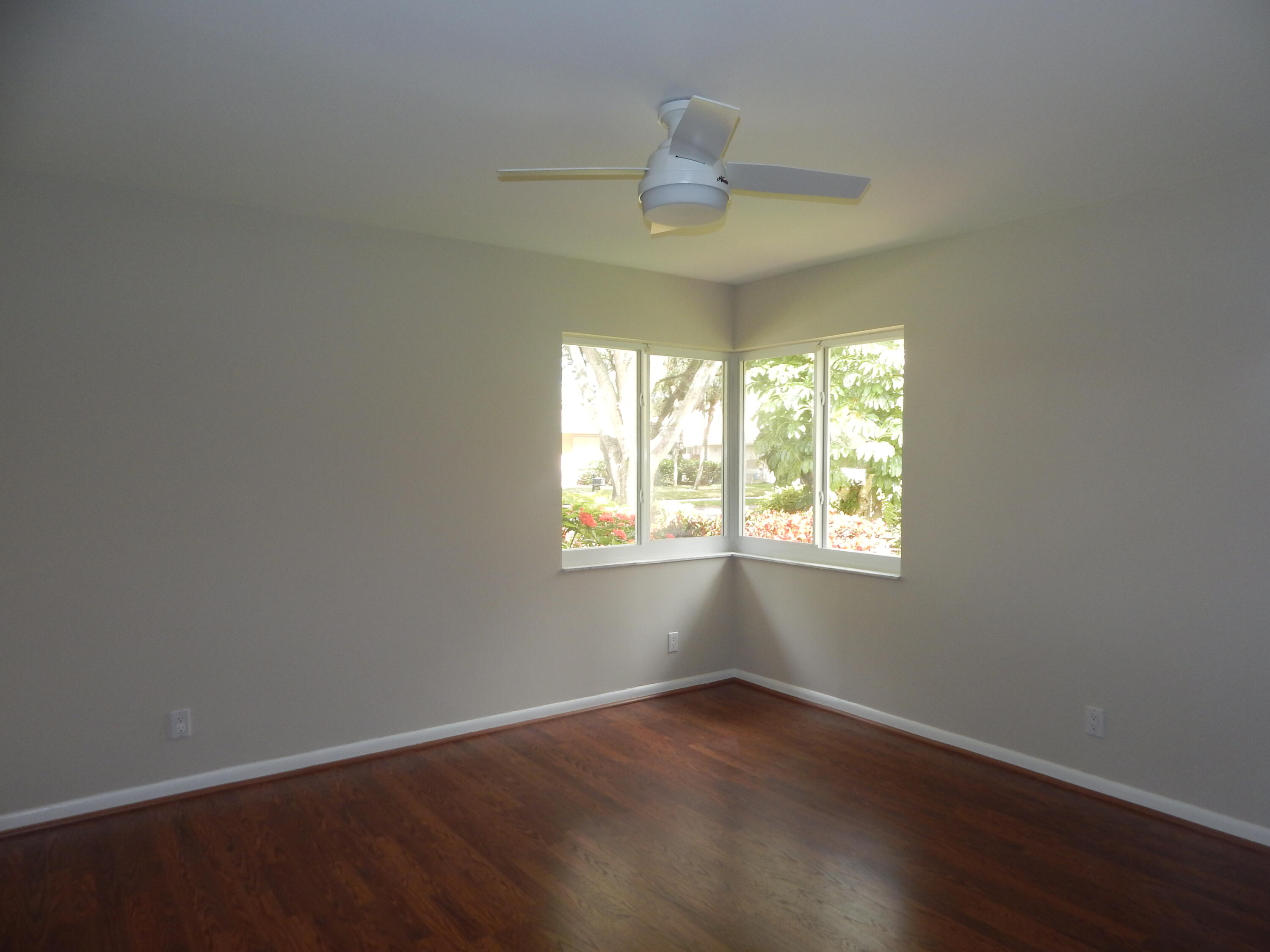 2530 Northwest 40th Street Boca Raton, FL 33434 - Photo 18 of 35 an empty room with wooden floor chandelier and window