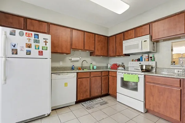 a kitchen with stainless steel appliances granite countertop a sink and a refrigerator