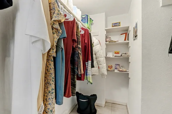 a view of walk in closet with clothes and shoes