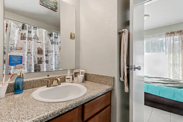 a bathroom with a granite countertop sink and a mirror