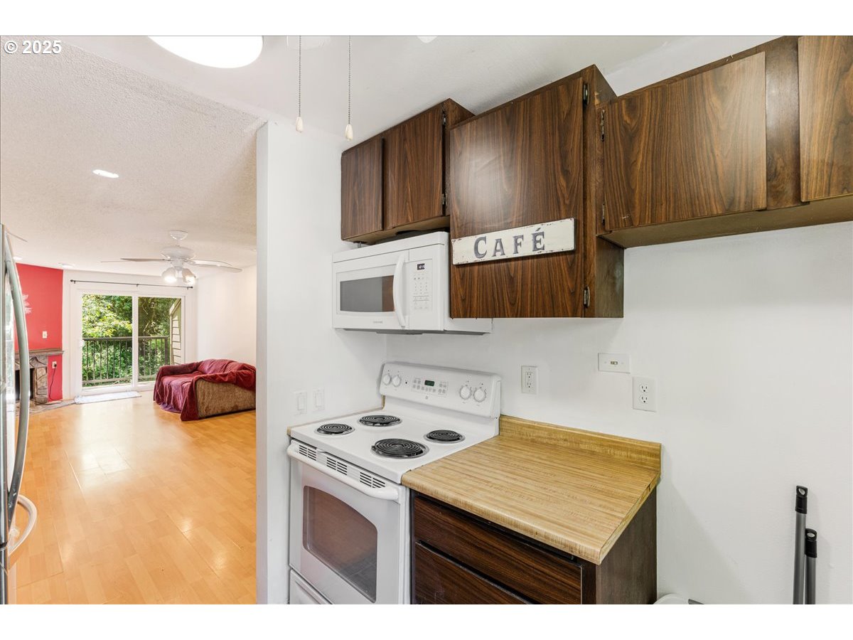 12620 Northwest Barnes Road, Unit 5 Portland, OR 97229 - Photo 10 of 26 a kitchen with stainless steel appliances a stove a microwave a sink and cabinets