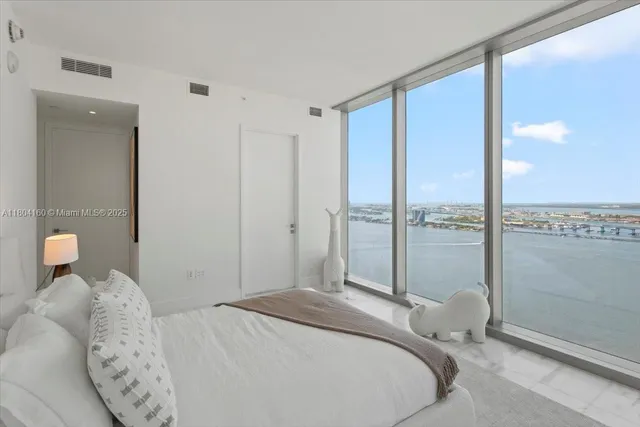 a bedroom with a large bed and a large window