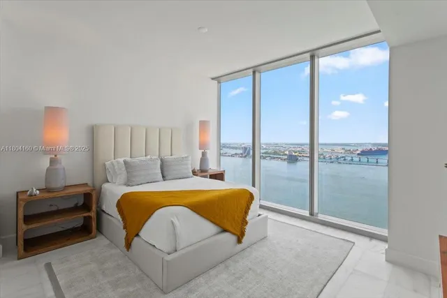 a bedroom with a large bed and a lamp next to a window