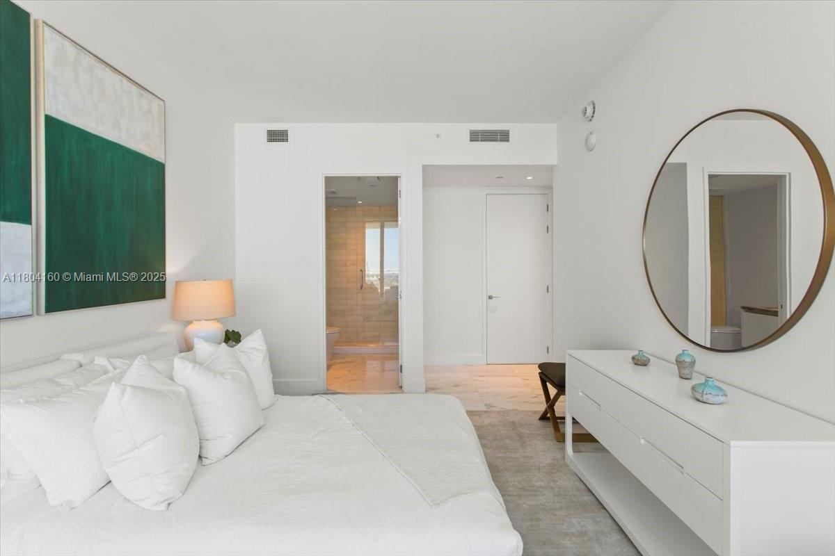 700 Northeast 26th Terrace, Unit 3903 Miami, FL 33137 - Photo 25 of 42 a bedroom with a bed and a mirror
