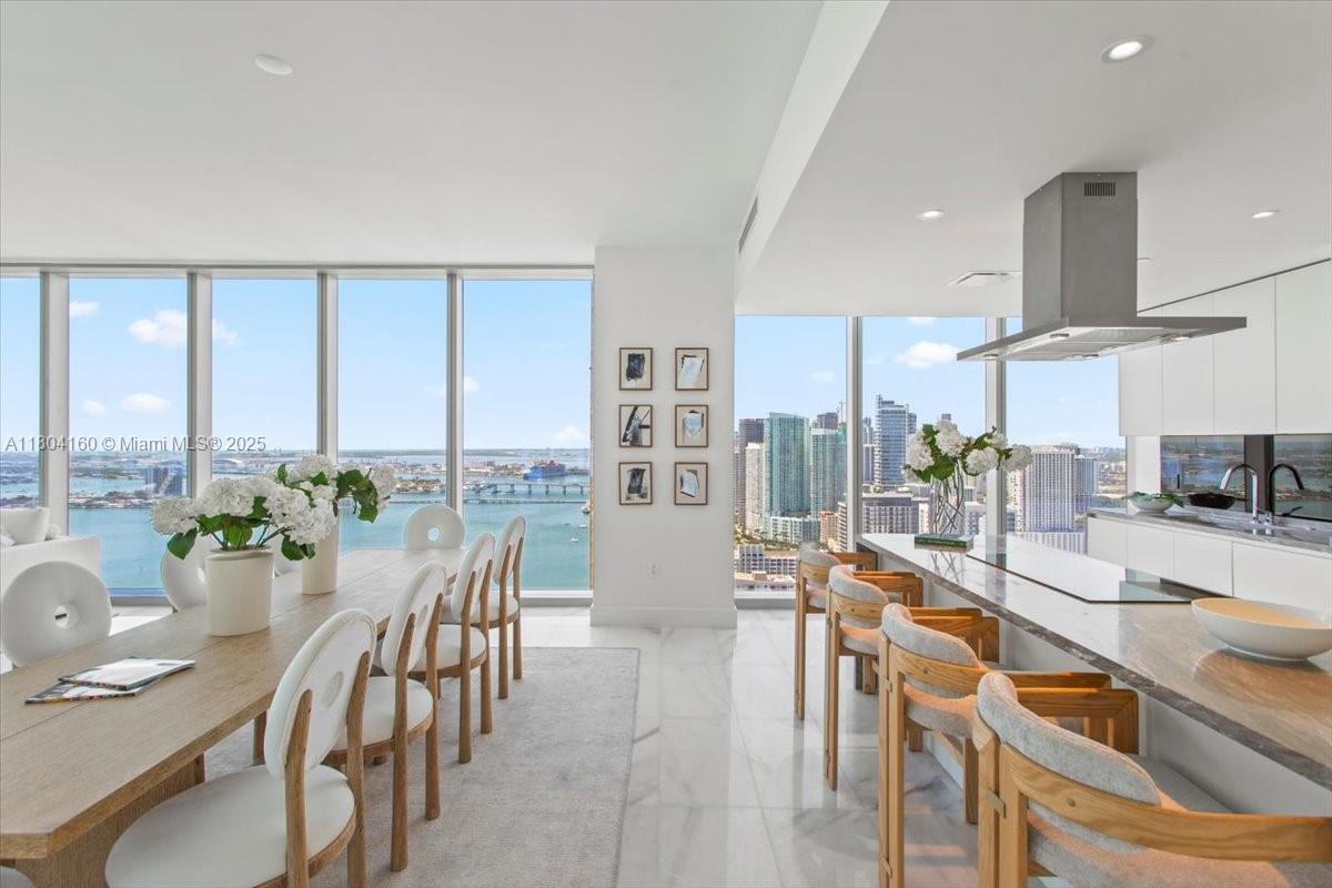 700 Northeast 26th Terrace, Unit 3903 Miami, FL 33137 - Photo 9 of 42 a dining room with furniture a large window and a kitchen view