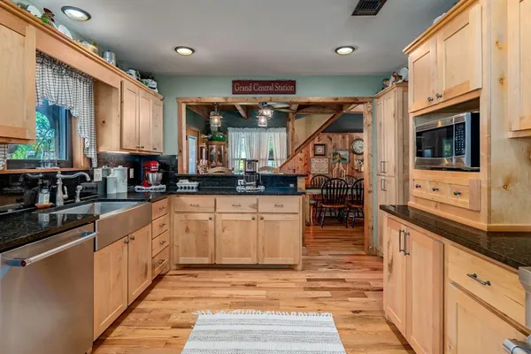 a kitchen with stainless steel appliances kitchen island granite countertop a stove and cabinets