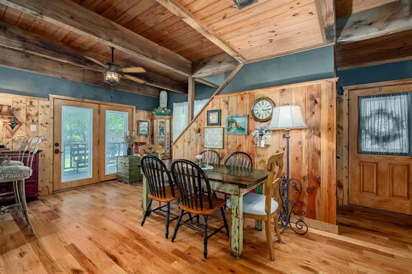 a dining room with wooden floor table and chairs