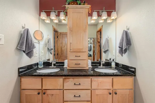 a bathroom with a granite countertop sink and a mirror
