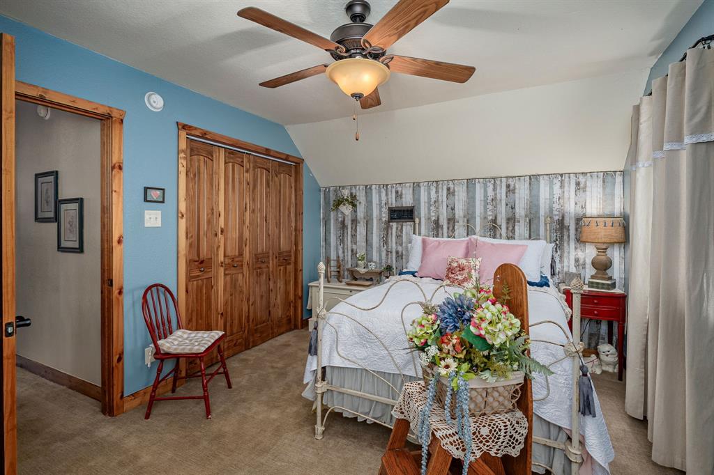 14392 Highway 78 Blue Ridge, TX 75424 - Photo 24 of 40 a bedroom with a bed and a chandelier