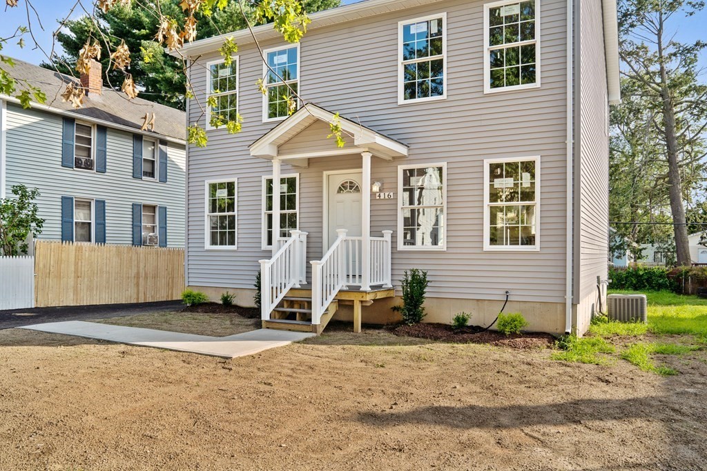 416 Nottingham Street Springfield, MA 01104 - Photo 3 of 20 a view of a white house with a yard and lawn chairs under a large tree