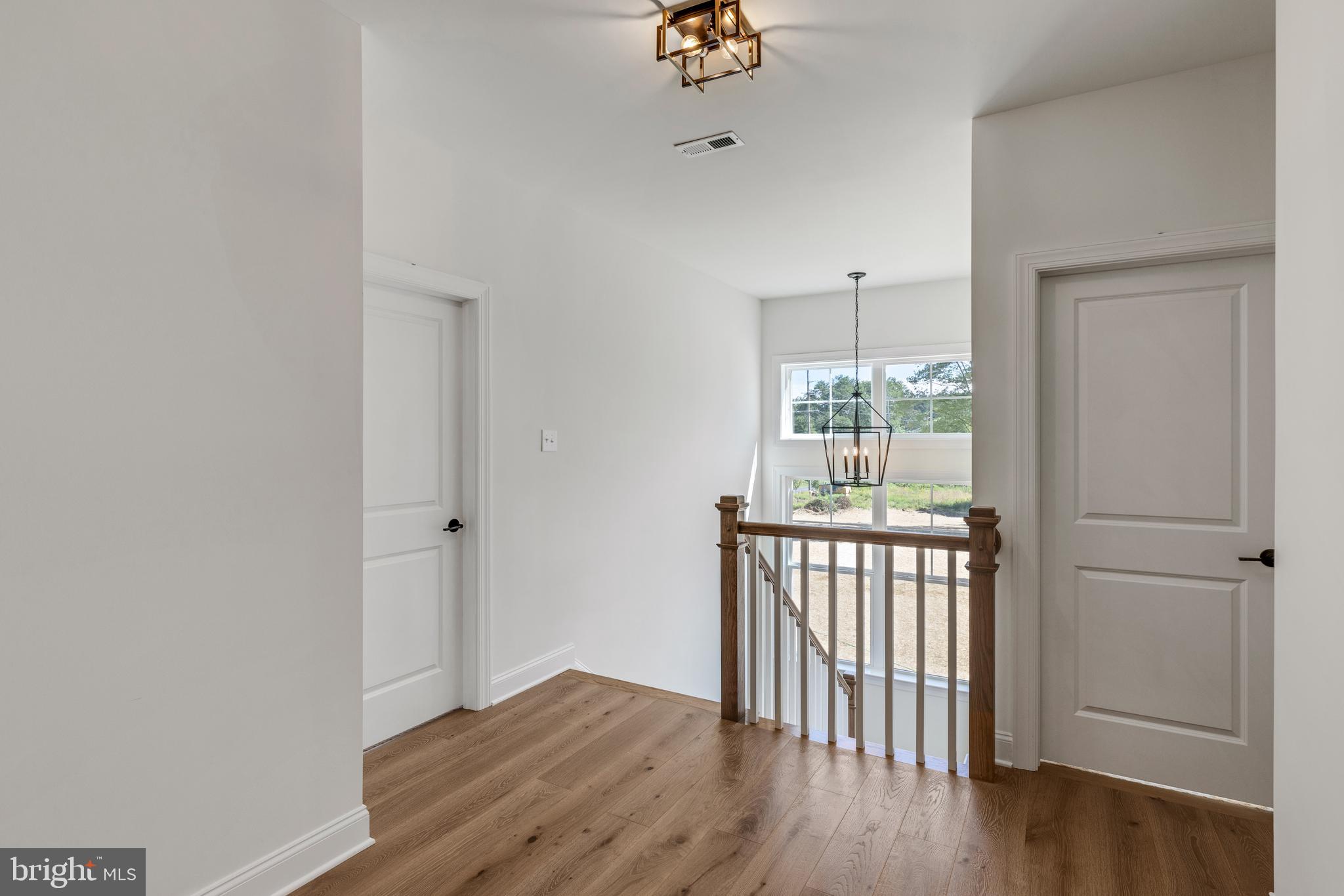 736 Northbrook Road, Unit S4 Kennett Square, PA 19348 - Photo 19 of 45 a view of a hallway with wooden floor and chandelier