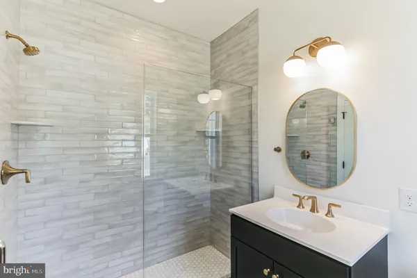 a bathroom with a sink a mirror and a shower
