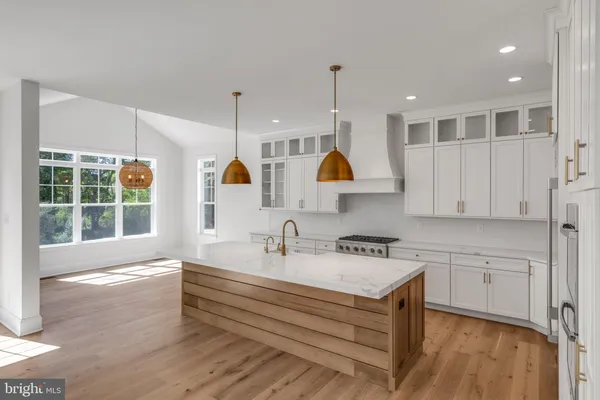 a kitchen that has a lot of cabinets in it and wooden floors