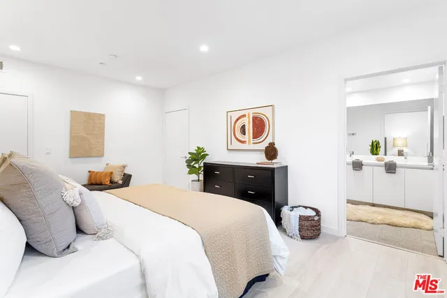 a bedroom with a bed and painting on the wall