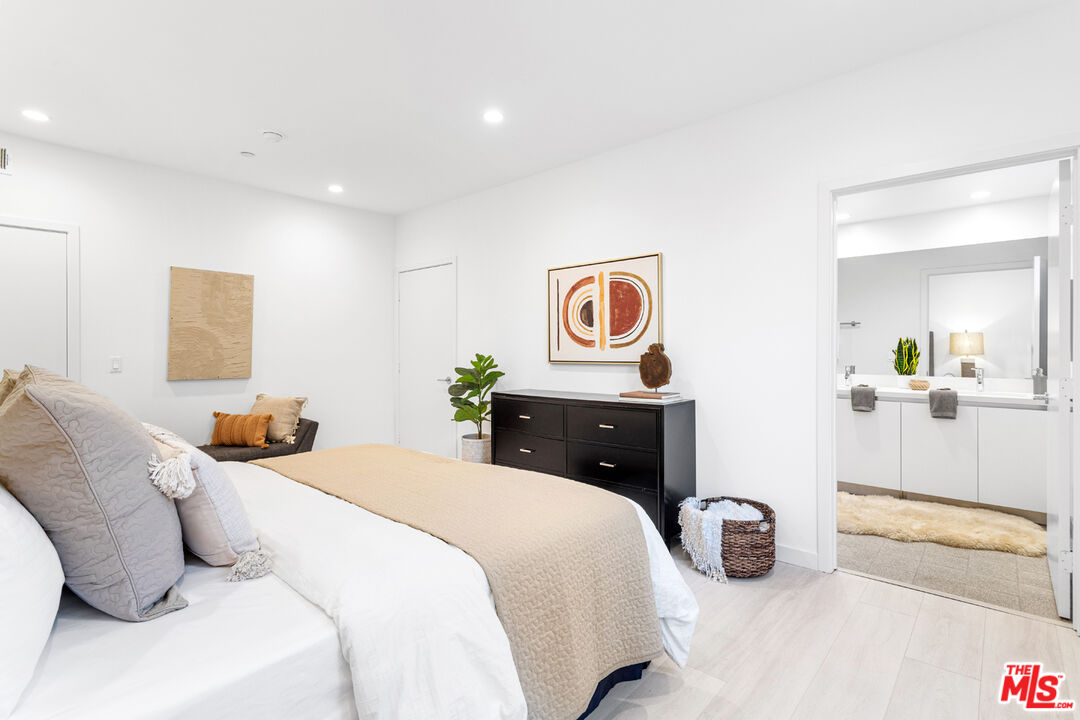 11620 Chenault Street, Unit 103 Los Angeles, CA 90049 - Photo 11 of 21 a bedroom with a bed and painting on the wall