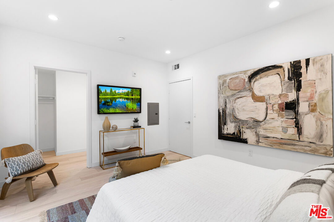 11620 Chenault Street, Unit 103 Los Angeles, CA 90049 - Photo 13 of 21 a bedroom with furniture and a flat screen tv