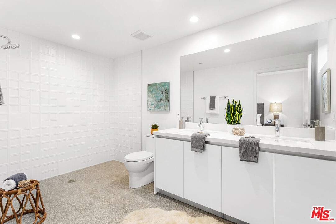 11620 Chenault Street, Unit 103 Los Angeles, CA 90049 - Photo 16 of 21 a living room with furniture a rug and a potted plant